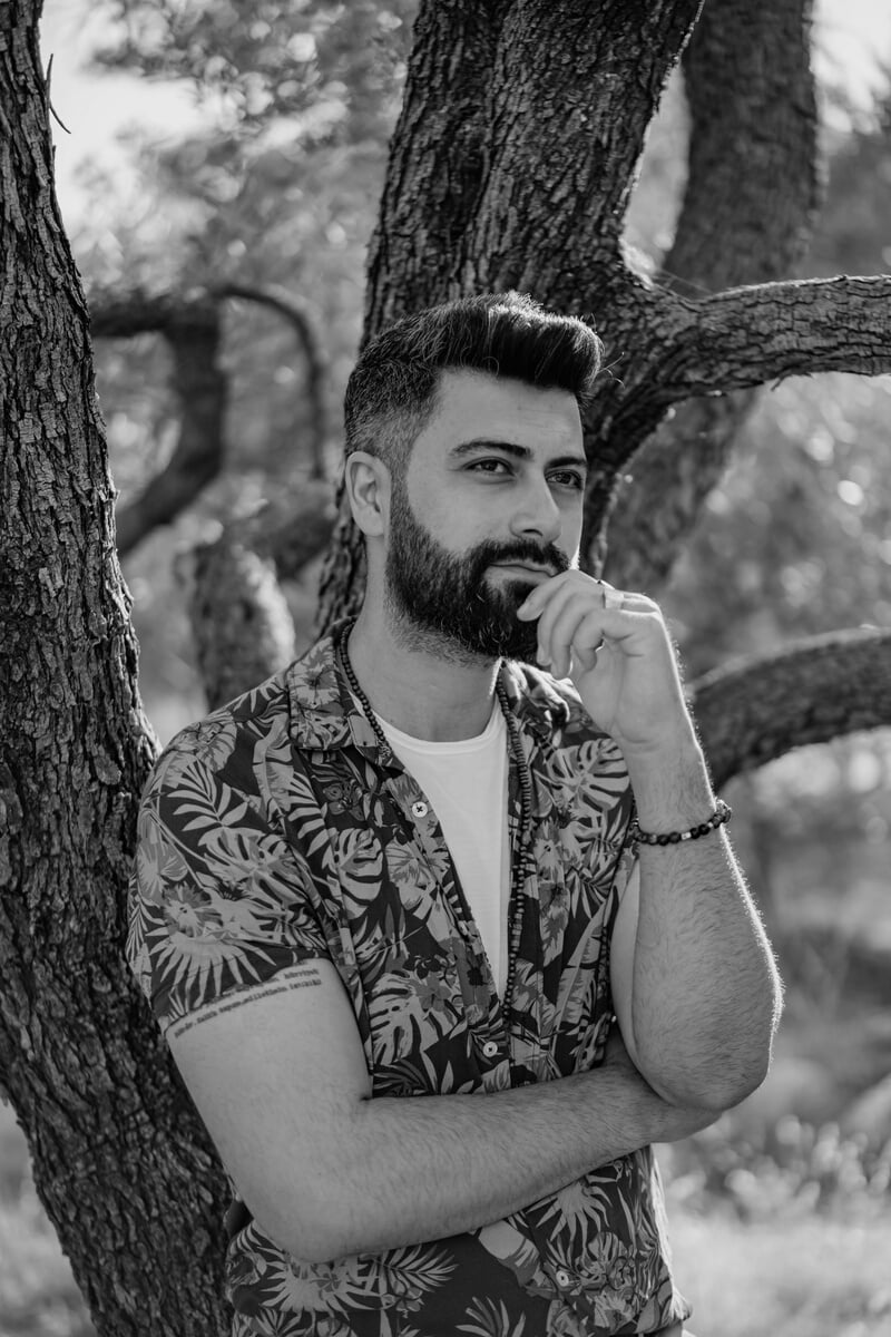 A Man in Printed Shirt Leaning on a Tree